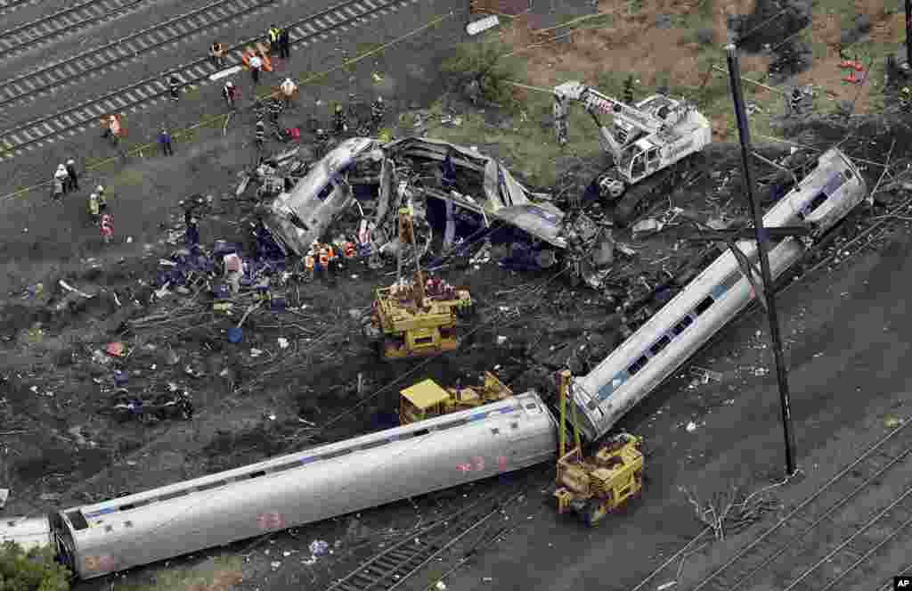 Petugas keadaan darurat bekerja di lokasi kecelakaan kereta di Philadelphia. Kereta Amtrak, menuju ke kota New York, keluar dari jalurnya di Philadelphia, menewaskan setidaknya enam orang dan melukai lebih dari 200 orang.