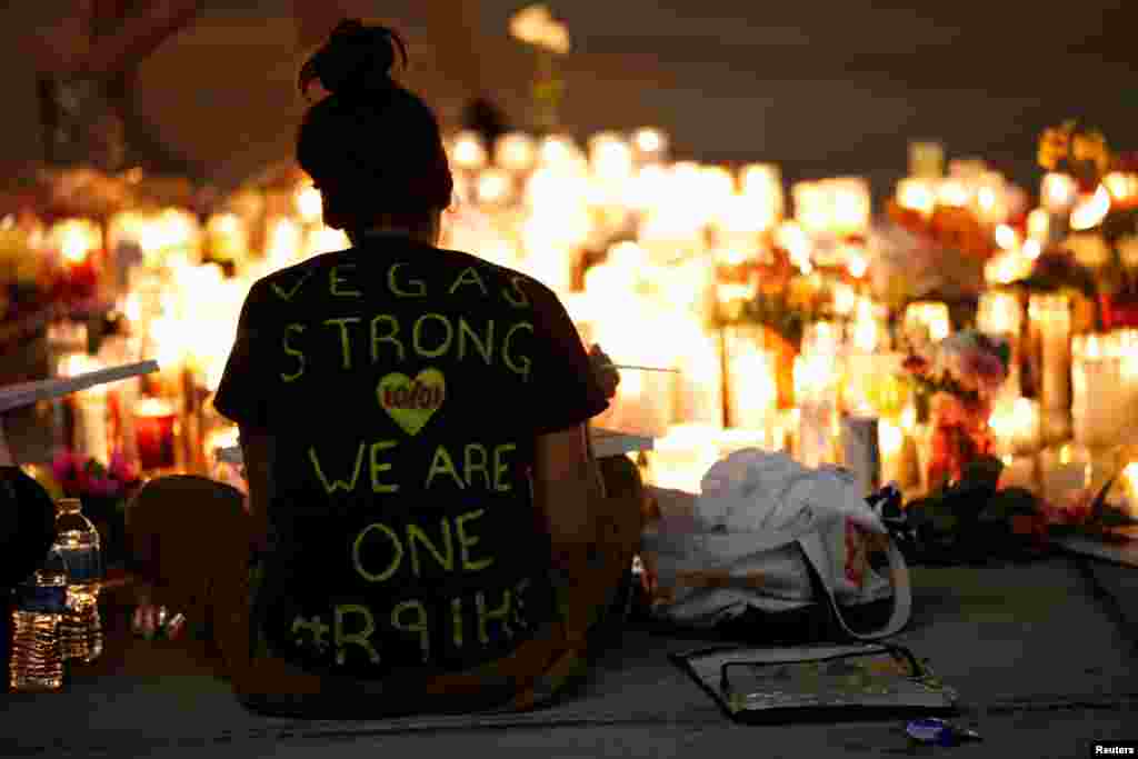 A woman makes a sign at a vigil on the Las Vegas strip following a mass shooting at the Route 91 Harvest Country Music Festival in Las Vegas, Nevada, Oct. 2, 2017.