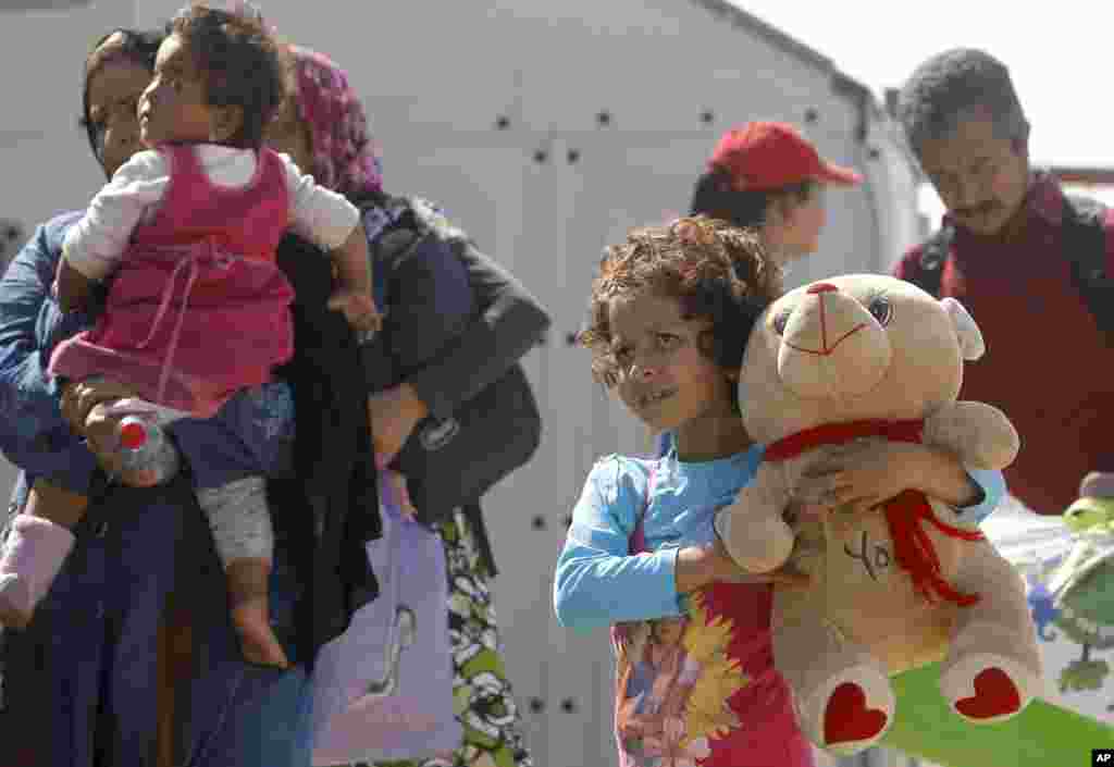 A girl hugs a teddy bear on the arrival at a transit camp near the southern Macedonian town of Gevgelija, after crossing the border with Greece.