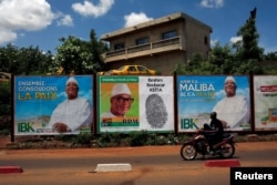 A man rides his motorcycle next to the electoral bilibaords of Ibrahim Boubacar Keita, the Malian president and leader of RPM (Rassemblement Pour le Mali), in Bamako, Mali July 23, 2018.