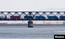 Trucks drive on the Friendship Bridge over the Yalu River which connects North Korea's Sinuiju to China's Dandong, April 11, 2013.