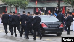 Các vệ sĩ chạy theo chiếc limousine chở lãnh đạo Triều Tiên Kim Jong Un từ ga Đồng Đăng đi Hà Nội ngày 26/2/2019. 