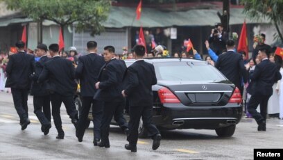 Các vệ sĩ chạy theo chiếc limousine chở lãnh đạo Triều Tiên Kim Jong Un từ ga Đồng Đăng đi Hà Nội ngày 26/2/2019. 
