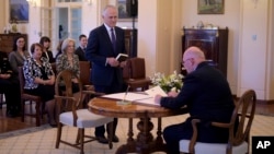 Malcolm Turnbull, center, is sworn in by Australia's Governor-General Sir Peter Cosgrove, right, as prime minister at Government House in Canberra, Tuesday, Sept. 15, 2015.