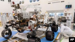 In this Dec. 17, 2019 file photo made available by NASA, engineers monitor a driving test for the Mars rover Perseverance in a clean room at the Jet Propulsion Laboratory in Pasadena, Calif. (J. Krohn/NASA via AP, File)