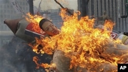 Effigy of North Korea's Kim Jong Un on burning mock missile at Seoul protest, South Korea, April 13, 2012.