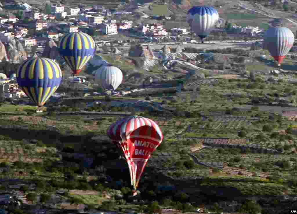 A hot air balloon falls to the ground after colliding with another during a trip in Cappadocia near Neveshir, Turkey. Two Brazilian tourists died and 23 other people were hurt after two hot-air balloons collided in a scenic area in central Turkey, officials said.