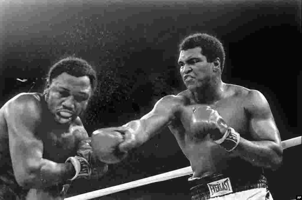 រូប​ឯកសារ៖​ ទឹក​បែក​ខ្ចាយ​ចេញ​ពី​កីឡាករ​ Joe Frazier ខណៈ​ដែល Muhammad Ali ​ជើង​ឯក​ទម្ងន់​ធ្ងន់​ប្រើ​កណ្តាប់​ដៃ​ស្តាំ​វាយ​ នៅ​ជុំ​ទី​៩​នៃ​ការប្រកួត​ដណ្តើម​ខ្សែ​ក្រវ៉ាត់​នៅ​ក្នុង​ទីក្រុង​ម៉ានីល​ ប្រទេស​ហ្វីលីពីន​។