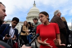 FILE - In this Nov. 14, 2018, file photo, Rep.-elect Alexandria Ocasio-Cortez, D-N.Y., talks with reporters following a photo opportunity on Capitol Hill in Washington, with the freshman class.
