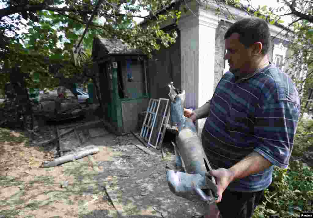 A man holds the remains of a rocket which he said was fired by Ukrainian army. Donetsk, Aug. 12, 2014.