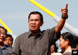 Cambodia's Prime Minister Hun Sen, center, gestures during a ceremony inaugurating the country's longest bridge in Neak Loeung, southeast of Phnom Penh, Cambodia, Wednesday, Jan. 14, 2015. Hun Sen, Cambodia's tough and wily prime minister, marks 30 years in power Wednesday, one of only a handful of political strongmen worldwide who have managed to cling to their posts for three decades. (AP Photo/Heng Sinith)