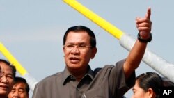 Cambodia's Prime Minister Hun Sen, center, gestures during a ceremony inaugurating the country's longest bridge in Neak Loeung, southeast of Phnom Penh, Cambodia, Wednesday, Jan. 14, 2015. Hun Sen, Cambodia's tough and wily prime minister, marks 30 years 