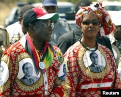FILE - Zimbabwe President Robert Mugabe and his wife, Grace, arrive at an election rally in Chivu, south of the capital Harare, March 28, 2005.