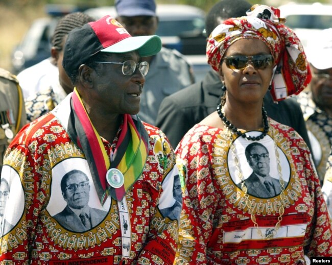 FILE - Zimbabwe President Robert Mugabe and his wife, Grace, arrive at an election rally in Chivu, south of the capital Harare, March 28, 2005.