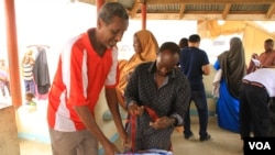 Workers help refugees check-in for repatriation flight to Mogadishu, Dadaab, Kenya, September 21, 2016.