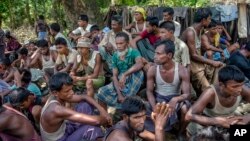 FILE - Rohingya Muslims from Myanmar wait to carry food items from Bangladesh's border toward a no man's land where they set up refugee camps in Tombru, Bangladesh, Sept. 15, 2017. 