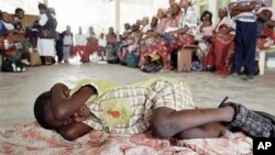 Menino espera ser testado para a malaria, em Manica, Mocambique.