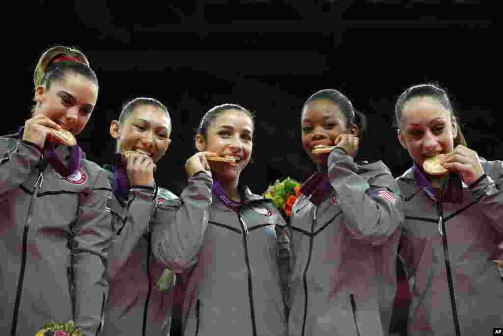 U.S. gymnasts McKayla Maroney, Kyla Ross, Alexandra Raisman, Gabrielle Douglas and Jordyn Wieber bite their gold medals at the Artistic Gymnastics women's team final at the 2012 Summer Olympics, July 31, 2012, in London.