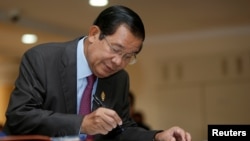 FILE - Cambodia's Prime Minister Hun Sen signs a register as he arrives before a plenary session at the National Assembly of Cambodia, in central Phnom Penh, Oct. 12, 2017.