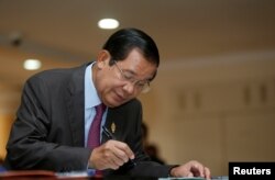 Cambodia's Prime Minister Hun Sen signs a register as he arrives before a plenary session at the National Assembly of Cambodia, in central Phnom Penh, Oct. 12, 2017.