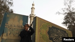 A man standing in front of Moqattam mosque takes a photo near the Muslim Brotherhood's national headquarters in Cairo's Moqattam district March 22, 2013.