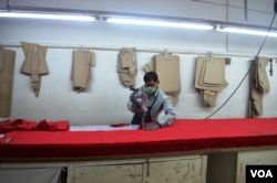 A worker is busy cutting garments at an apparel factory. (A. Pasricha/VOA)