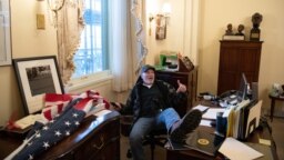 a supporter of Donald Trump sits inside the office of US Speaker of the House Nancy Pelosi 