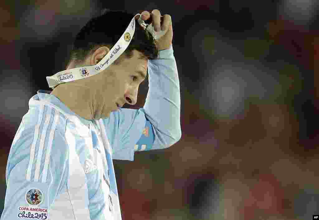Lionel Messi yana cire tasa lambar azurfa da aka ba &#39;yan wasan kasar Argentina, bayan da suka zo na biyu a gasar Copa America. &#39;Yan Chile suka doke su suka dauki kofin da kuma lambar zinare.
