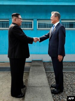 Pemimpin Korea Utara, Kim Jong-un (kiri) berjabat tangan dengan Presiden Korea Selatan, Moon Jae-in (kanan) di garis demarkasi militer yang memisahkan kedua negara, sebelum memulai KTT di desa Panmunjom, Korea Utara. (Foto: dok).