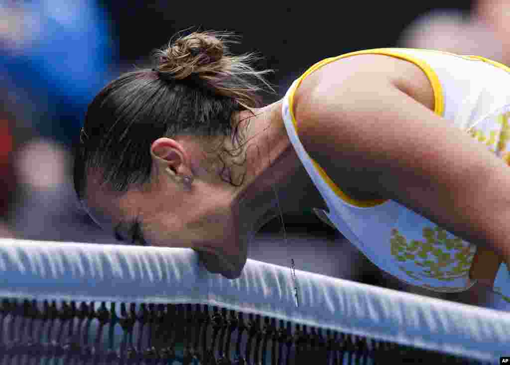 Flavia Pennetta of Italy bites the net in frustration during the fourth round match against Angelique Kerber of Germany at the Australian Open tennis championship in Melbourne, Australia.