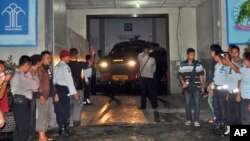 Police officers direct an armored car leading a convoy of vehicles carrying Mary Jane Veloso, a Filipino woman on death row for drug offenses, as it leaves a prison in Yogyakarta, Indonesia, for the prison island of Nusakambangan, April 24, 2015.