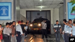 Polisi mengarahkan kendaraan lapis baja yang memimpin konvoi kendaraan yang diyakini membawa Mary Jane Veloso, perempuan Filipina terpidana hukuman mati, dari penjara di Yogyakarta ke Nusakambangan (24/4). (AP/Slamet Riyadi)