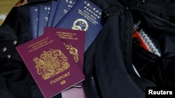 很多香港人目前分別擁有英國國民海外護照（BNO) 和香港特區護照 （路透社照片/Reuters Photo）