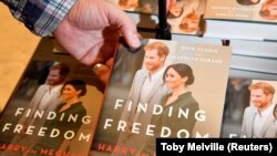Seorang memegang buku’ Finding Freedom', biografi tidak resmi tentang Pangeran Harry dan Meghan, Inggris, 12 Agustus 2020. Duchess of Sussex akan menerbitkan buku anak-anak bulan depan, berjudul "The Bench." (Foto: REUTERS/Toby Melville)