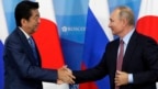 Thủ tướng Nhật Bản Shinzo Abe (trái) bắt tay Tổng thống Nga Vladimir Putin trong một buổi gặp tại Vladivostok, Nga, hôm 10/10.