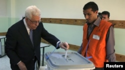 Palestinian President Mahmoud Abbas casts his vote for municipal elections at a polling station in Al-Bireh, next to the West Bank city of Ramallah, October 20, 2012. 