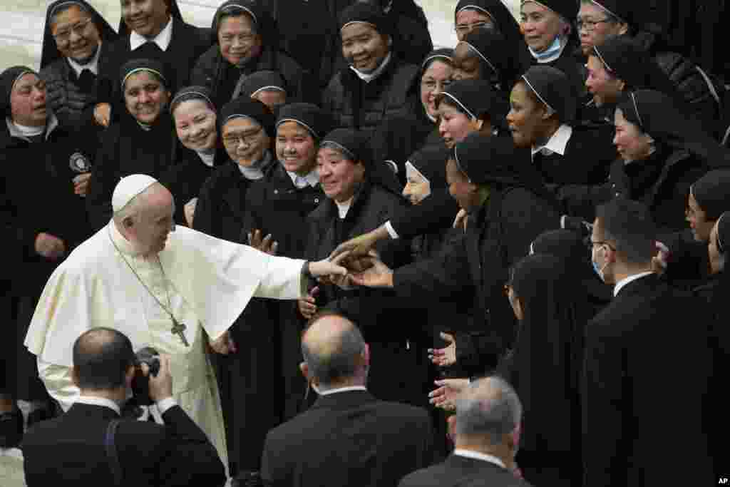 Pope Francis is cheered by nuns at the end of his weekly general audience in the Paul VI Hall at the Vatican.