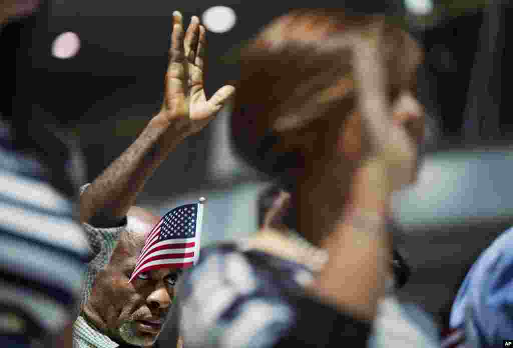 Mamadou Lawal Diallo, asal Guinea, mengangkat Oath of Allegiance (Sumpah Setia) pada acara naturalisasi di Atlanta, Georgia.&nbsp; Sembilan belas warga baru Amerika mengangkat sumpahnya sebagai WN AS di Balai Kota sebelum libur peringatan 4 Juli.