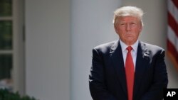 President Donald Trump stands next to the podium after speaking about the U.S. role in the Paris climate change accord in the Rose Garden of the White House in Washington, June 1, 2017. 