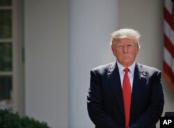FILE - President Donald Trump stands next to the podium after speaking about the U.S. role in the Paris climate change accord in the Rose Garden of the White House in Washington, June 1, 2017.