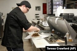 Chef Joseph Gattuso prepares a gyro sandwich. He's working in the kitchen of Frato's Pizza, but filling an online order for the virtual restaurant Halal Kitchen, in Schaumburg, Ill, on Sept. 6, 2019.