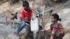 Anak-anak mengisi jerigen di sumber air di Desa Sanleo, Kabupaten Malaka, Nusa Tenggara Timur, 10 Oktober 2015. (Foto: Prasetyo Utomo/Antara via Reuters)