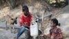 Anak-anak mengisi jerigen di sumber air di Desa Sanleo, Kabupaten Malaka, Nusa Tenggara Timur, 10 Oktober 2015. (Foto: Prasetyo Utomo/Antara via Reuters)