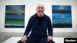Artist Sean Scully poses with his works "Landline Bruke 5.14" (L) and "Landline Blue Blue" at the Timothy Taylor Gallery in London, Nov. 20, 2014. 