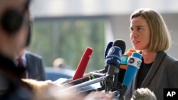 European Union High Representative Federica Mogherini, right, speaks with the media as she arrives for a meeting of EU foreign ministers at the EU Council building in Luxembourg, April 3, 2017.