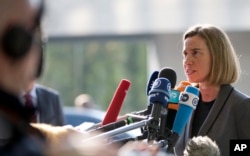 European Union High Representative Federica Mogherini, right, speaks with the media as she arrives for a meeting of EU foreign ministers at the EU Council building in Luxembourg, April 3, 2017.