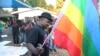 FILE - Samba Chesterfield, Director of Gays and Lesbians Association of Zimbabwe, prepares to hoist their official flag alongside the Zimbabwean flag during an event in Harare, Zimbabwe, May, 19, 2012. 