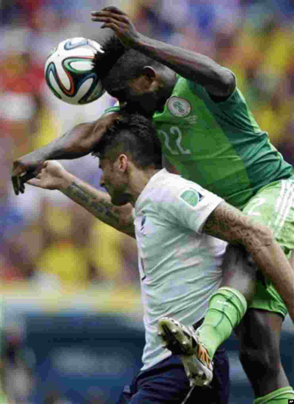 Nigeria's Kenneth Omeruo goes for a header with France's Olivier Giroud during the World Cup round of 16 soccer match between France and Nigeria at the Estadio Nacional in Brasilia, Brazil, Monday, June 30, 2014. (AP Photo/Ricardo Mazalan)