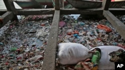 A Bangladeshi homeless child sleeps on a garbage bag on the bank of polluted river Buriganga on World Water Day in Dhaka, Bangladesh, Sunday, March 22, 2015. The U.N. warns that the world could suffer a 40 percent shortfall in water by 2030 unless countri