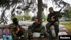 Armed militiamen supporting the self-proclaimed Donetsk People's Republic guard a checkpoint in the eastern Ukrainian city of Donetsk, June 1, 2014.